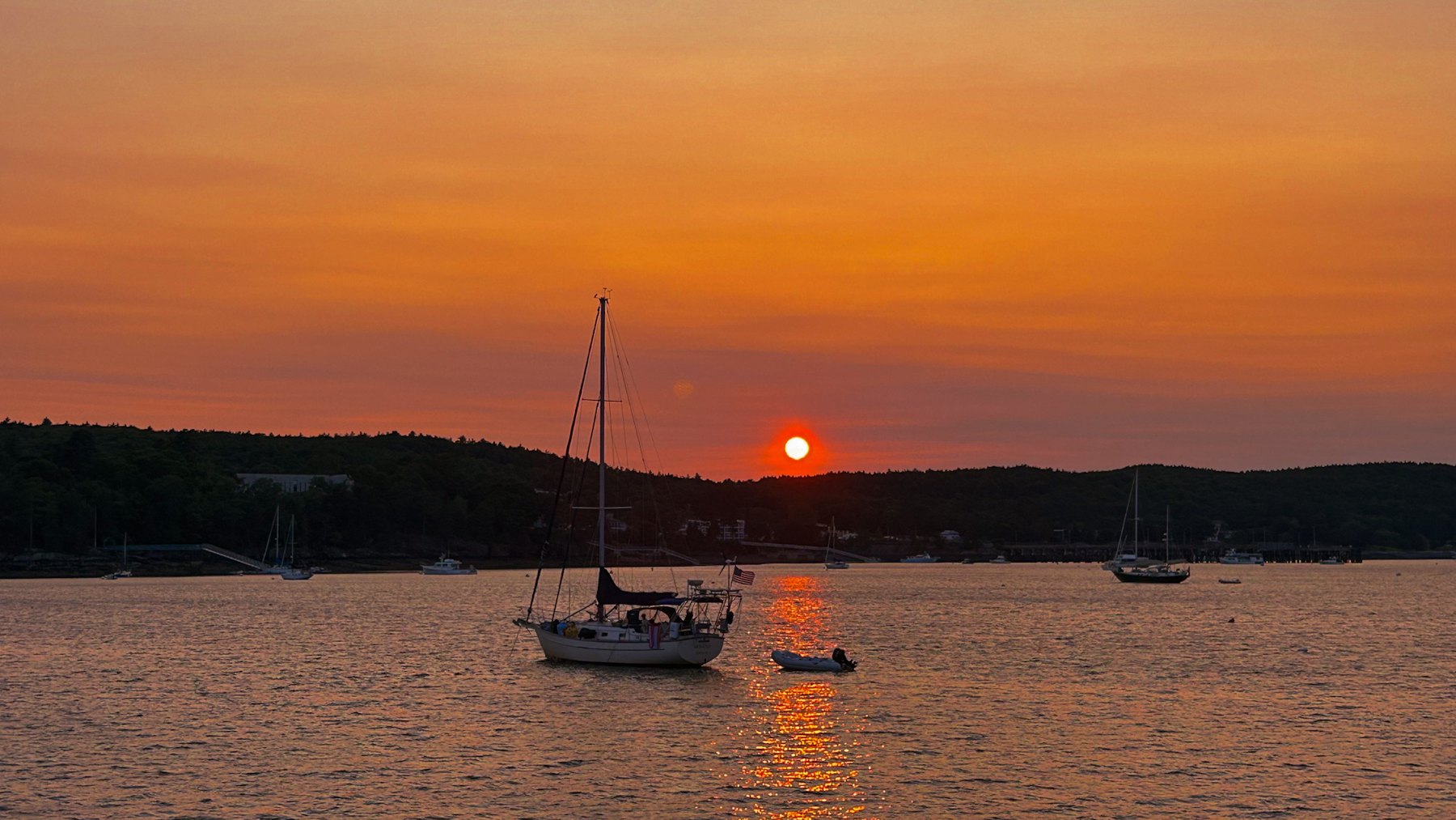Sailboats on calm water at sunset